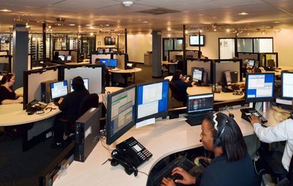 Office call center with rows of computers and people working at desks