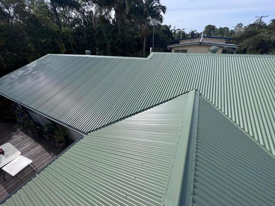 Green Corrugated Metal Roof on a House, Viewed From Above, Surrounded by Trees — Rumara Roofing in Caboolture, QLD
