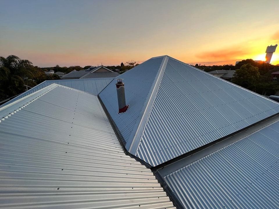 Metal Roof With a Chimney Against a Sunset, Seen From Above — Rumara Roofing in Landsborough, QLD