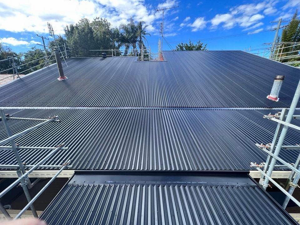 Black Corrugated Metal Roof With Scaffolding, Blue Sky —Rumara Roofing in Buderim, QLD