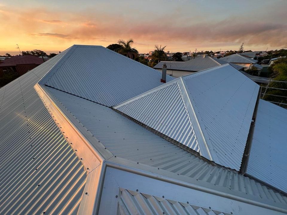 Corrugated Metal Roof on a House With a Sunset in the Background — Rumara Roofing in Mountain Creek, QLD