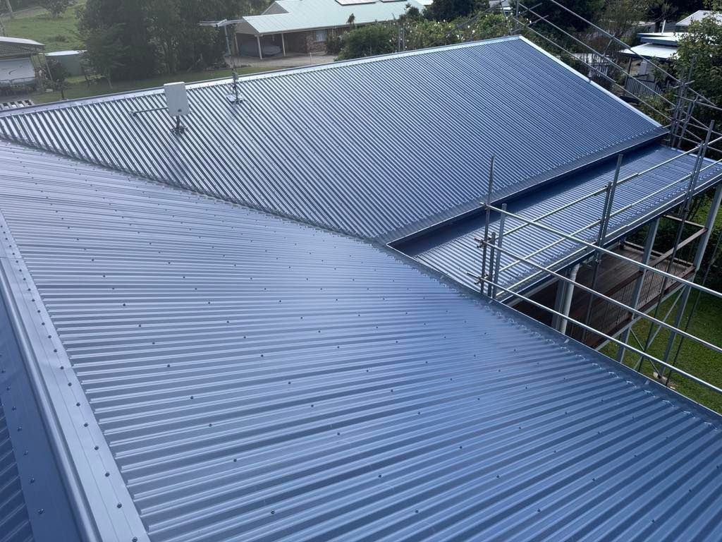Gray Corrugated Metal Roof With Scaffolding on a Building Exterior — Rumara Roofing in Sunshine Coast, QLD