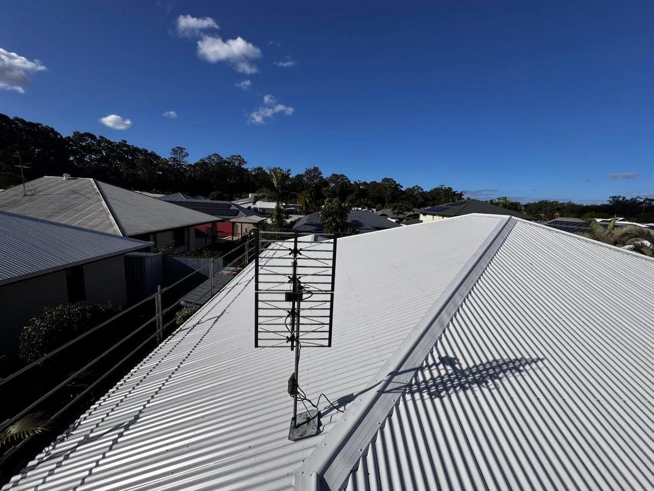 Television Antenna on a White Corrugated Metal Roof Under a Bright Blue Sky — Rumara Roofing in Sunshine Coast, QLD