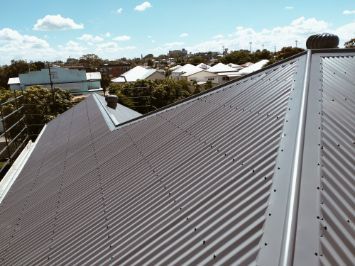 Gray Corrugated Metal Roof on a Residential Building With a Cityscape — Rumara Roofing in Sunshine Coast, QLD