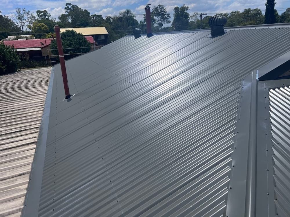 Gray Corrugated Metal Roof With Several Vents and Pipes — Rumara Roofing in Sunshine Coast, QLD