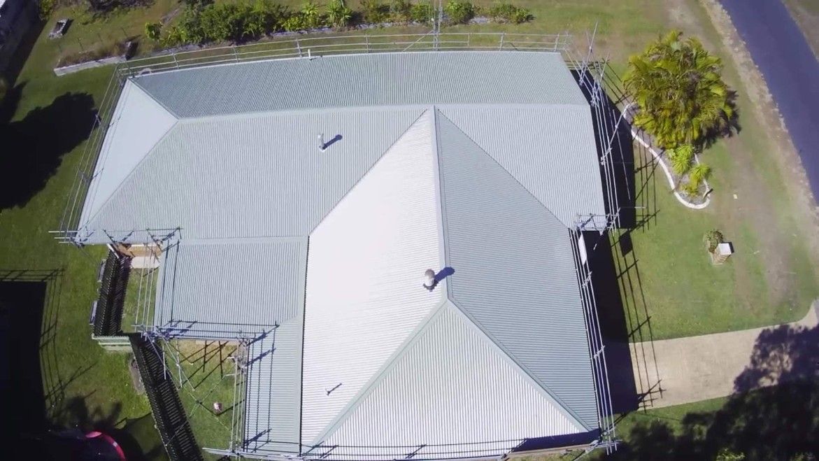 Overhead View of a Metal Roof on a House. Green Grass and a Road Are Visible — Rumara Roofing in Gympie, QLD