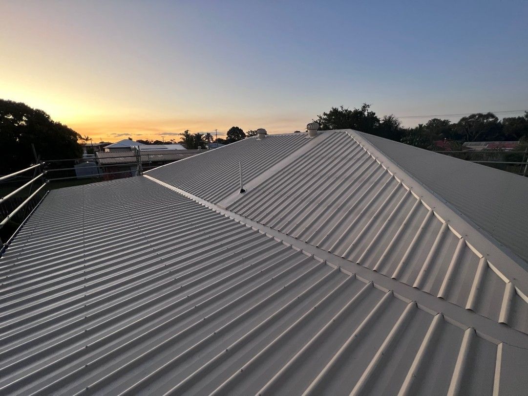 Corrugated Metal Roof at Dusk With a Sunset in the Background — Rumara Roofing in Nambour, QLD