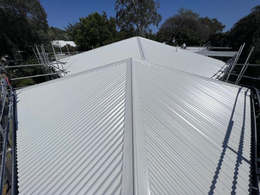 White Corrugated Metal Roof With Scaffolding, Trees in Background — Rumara Roofing in Nambour, QLD