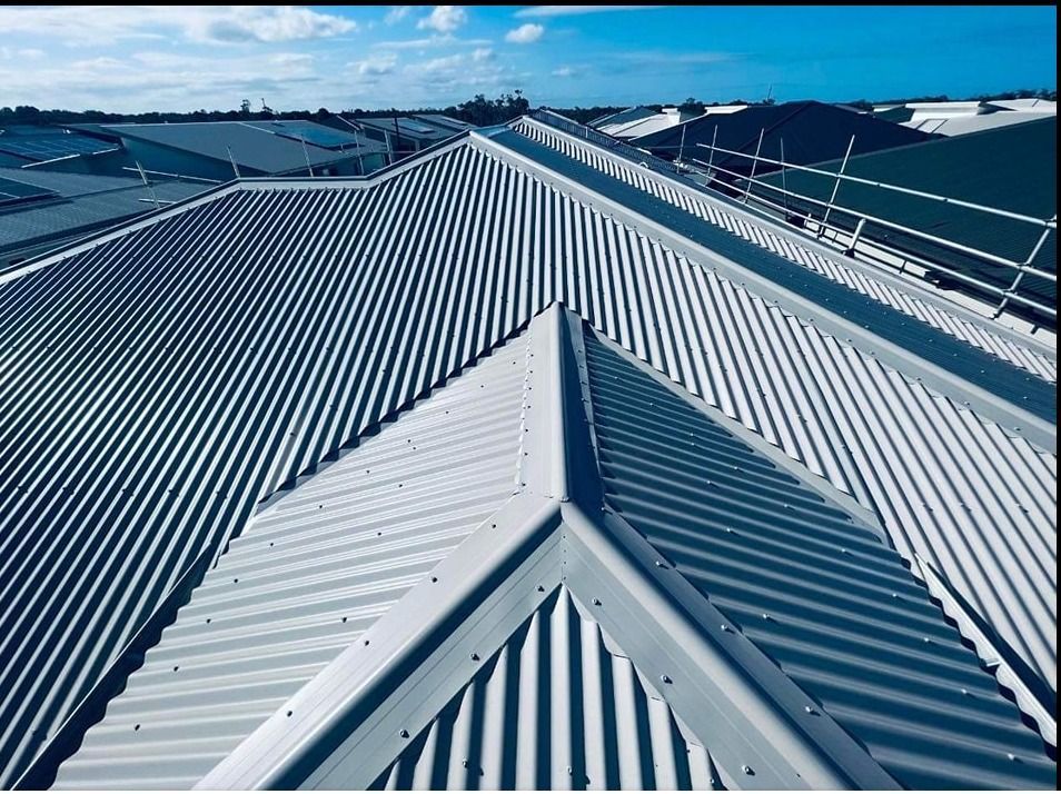 View of a Gray Corrugated Metal Roof With a Ridge and Clear Blue Sky — Rumara Roofing in Sunshine Coast, QLD