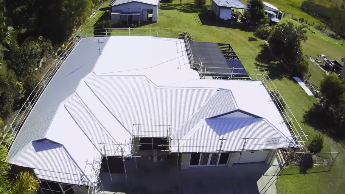Aerial View of a House With a New White Metal Roof and Scaffoldings — Rumara Roofing in Maroochydore, QLD