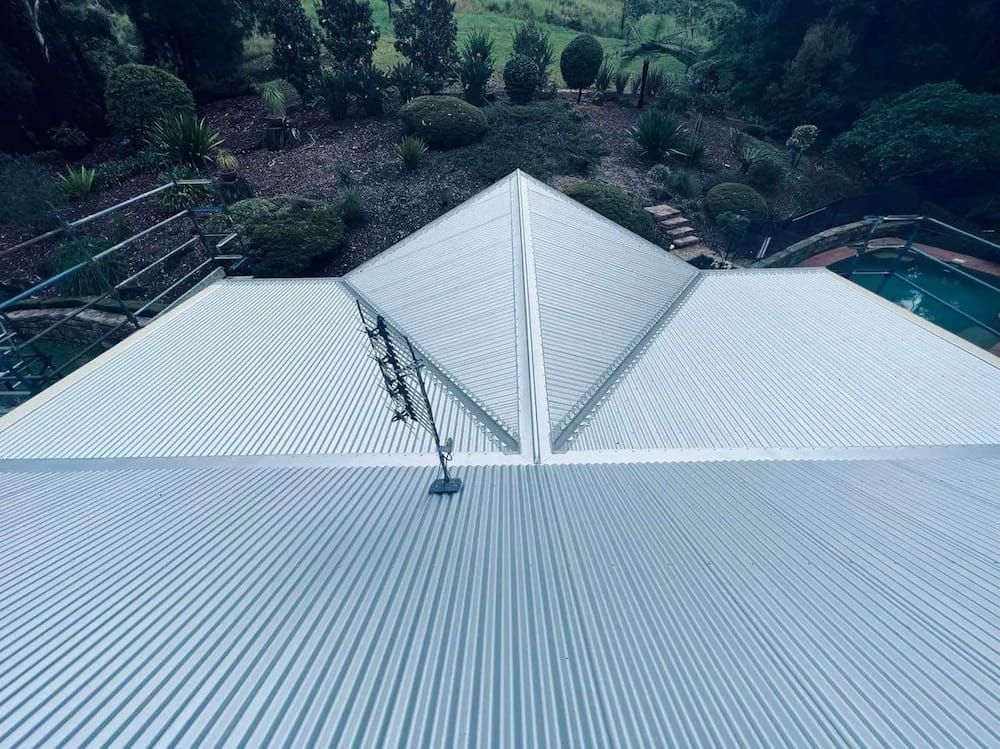 Overhead View of a Corrugated Metal Roof With a Pool and Green Foliage — Rumara Roofing in Maroochydore, QLD