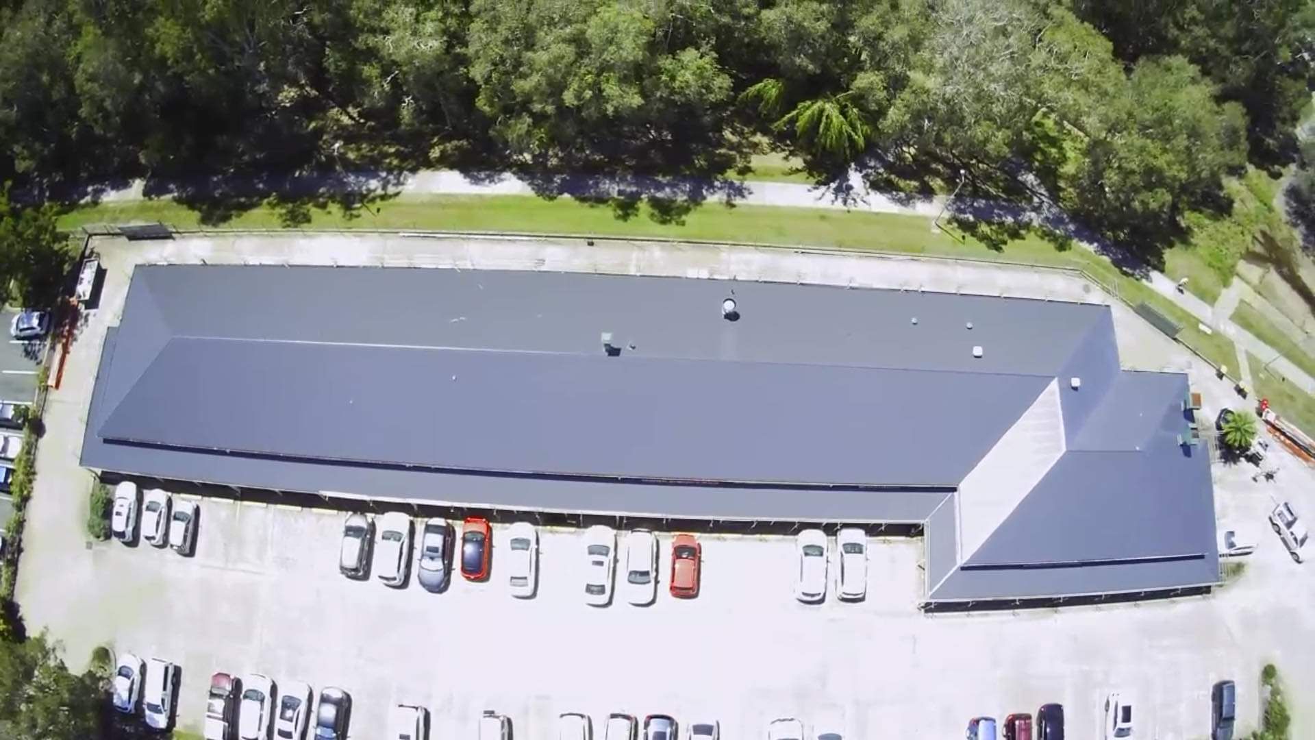 Aerial View of a Long, Gray-roofed Building With Cars Parked in Front — Rumara Roofing in Sunshine Coast, QLD