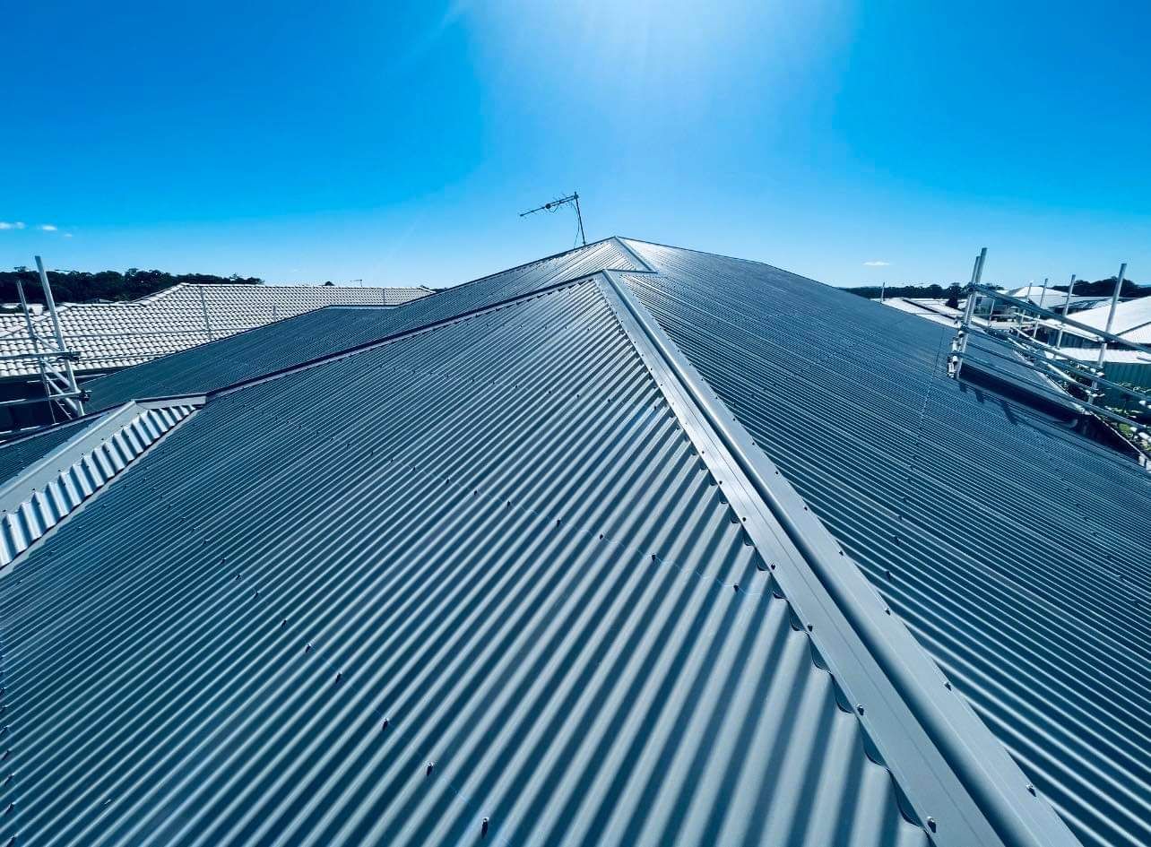 Blue Metal Corrugated Roof on a Building Under a Bright Blue Sky — Rumara Roofing in Sunshine Coast, QLD