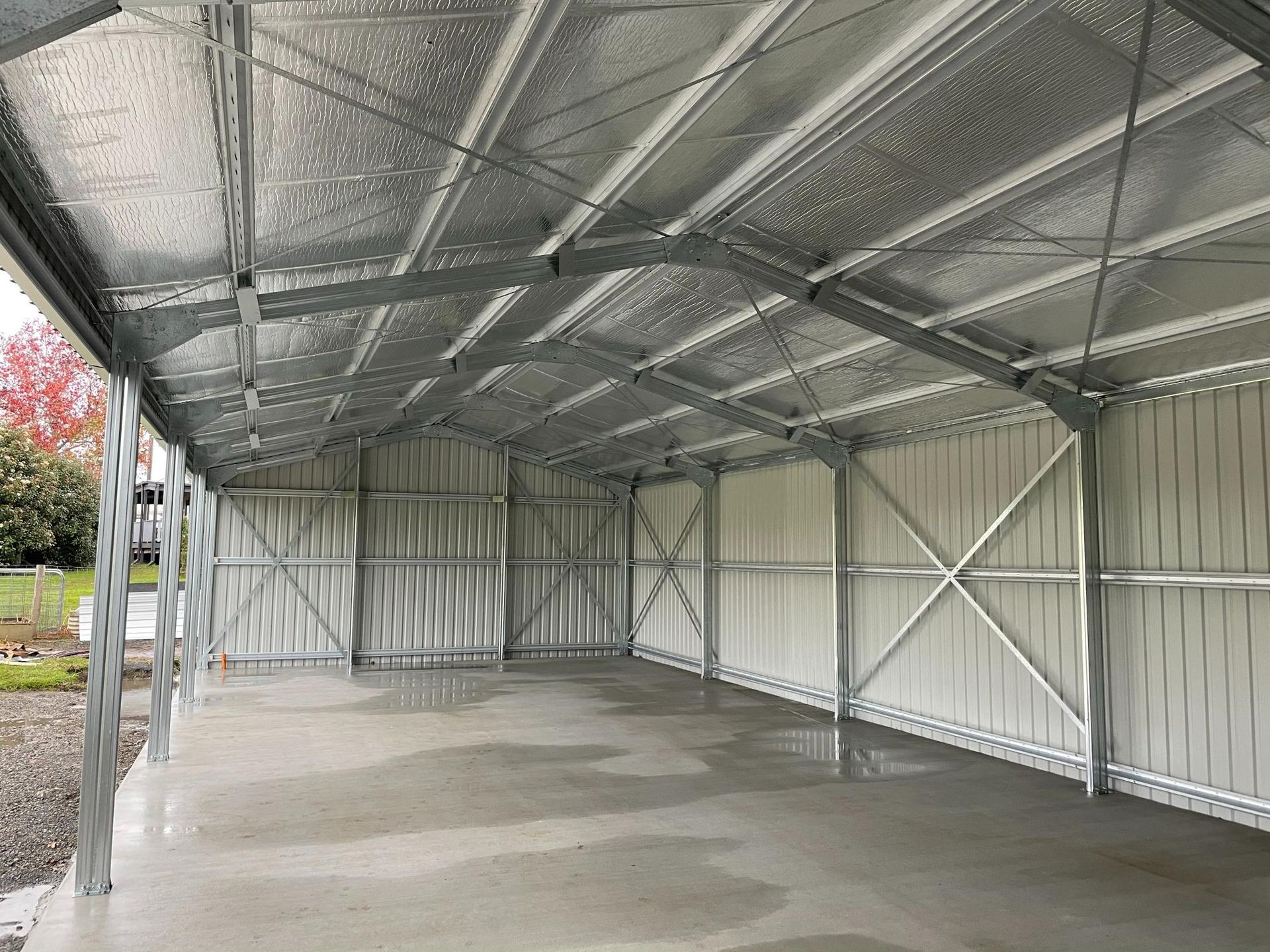 Empty Metal Carport with A Corrugated Roof and Concrete Floor — Bridgey's Constructions in Wallabi Point, NSW