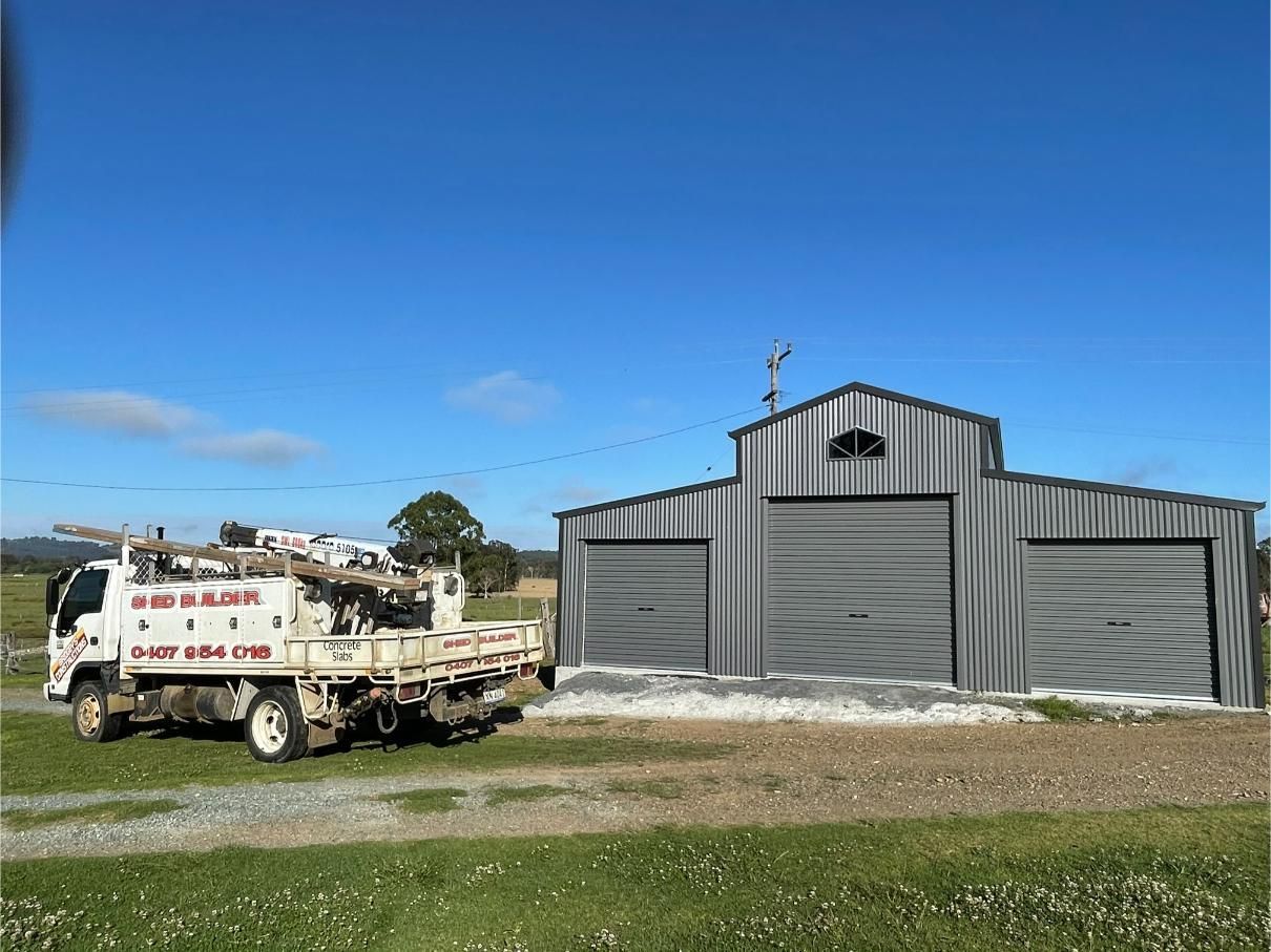 Truck Parked Next to a Grey Metal Shed — Bridgey's Constructions in Taree, NSW