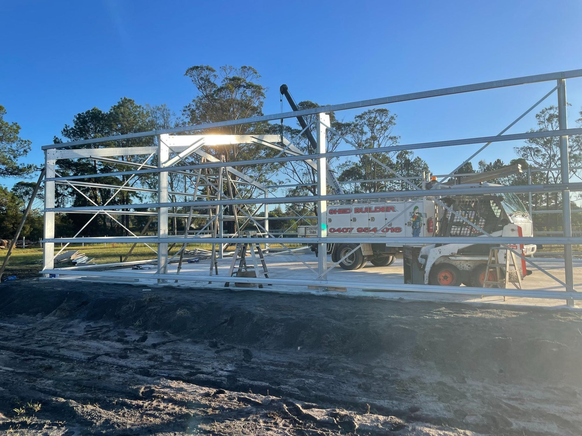 Steel frame building under construction on a sunny day, with crane and equipment visible in Port Macquarie, NSW. 