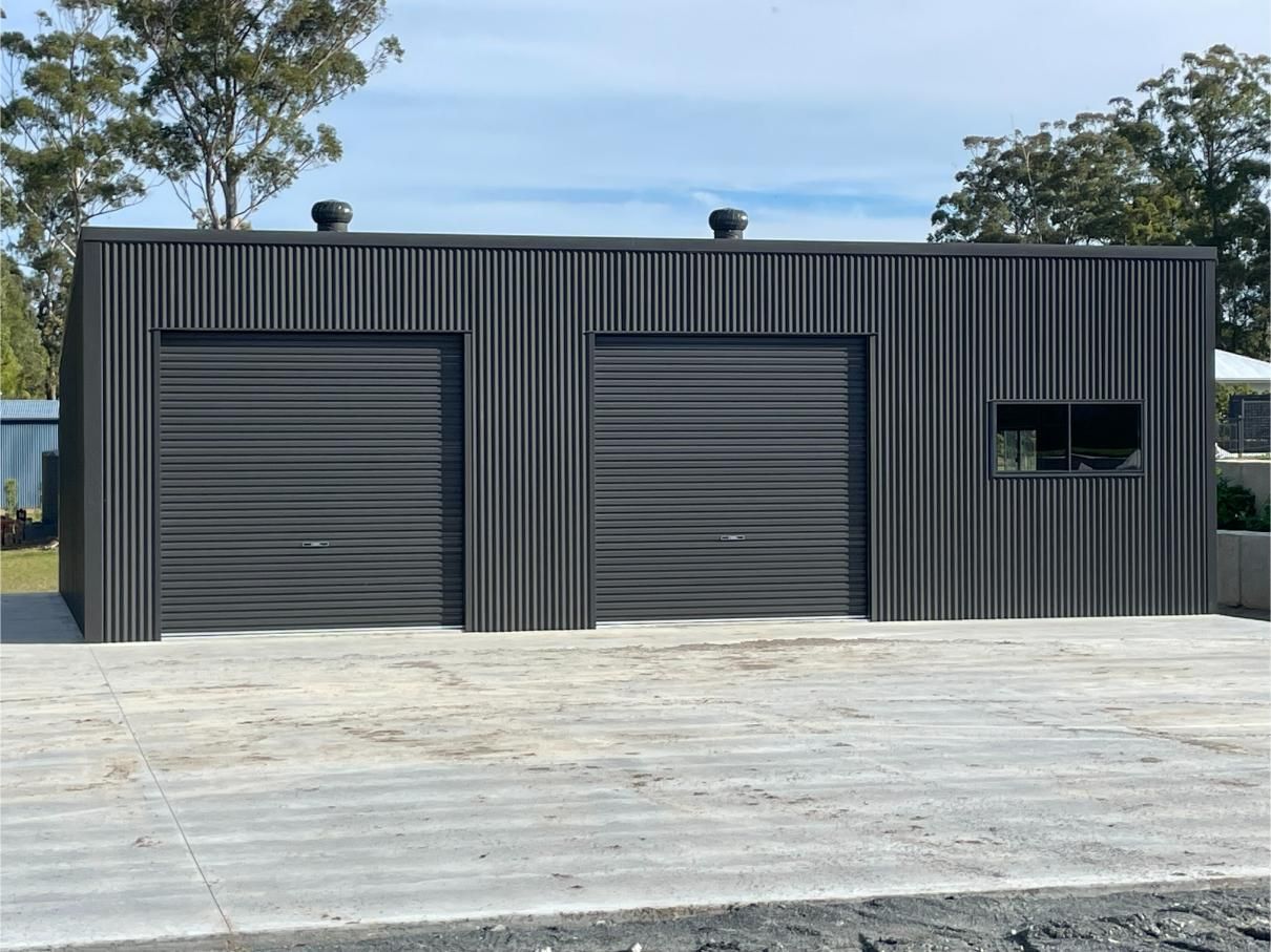 Black Corrugated Metal Building with Two Large Garage Doors — Bridgey's Constructions in Wallabi Point, NSW