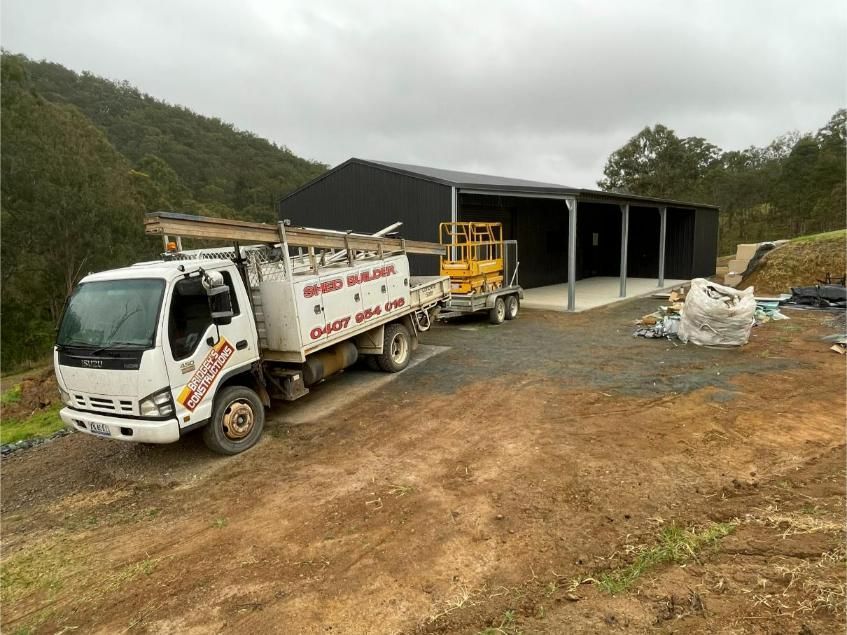 White Truck Parked Beside a Large Open Sided Shed on A Dirt Site — Bridgey's Constructions in Wallabi Point, NSW