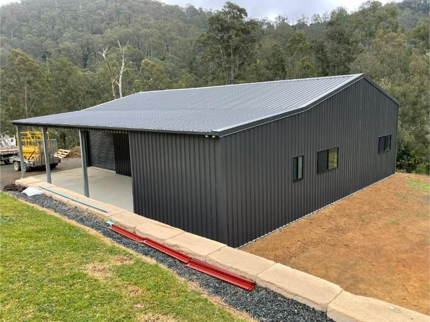 Black Metal Shed with A Gray Roof on A Concrete Slab — Bridgey's Constructions in Wallabi Point, NSW