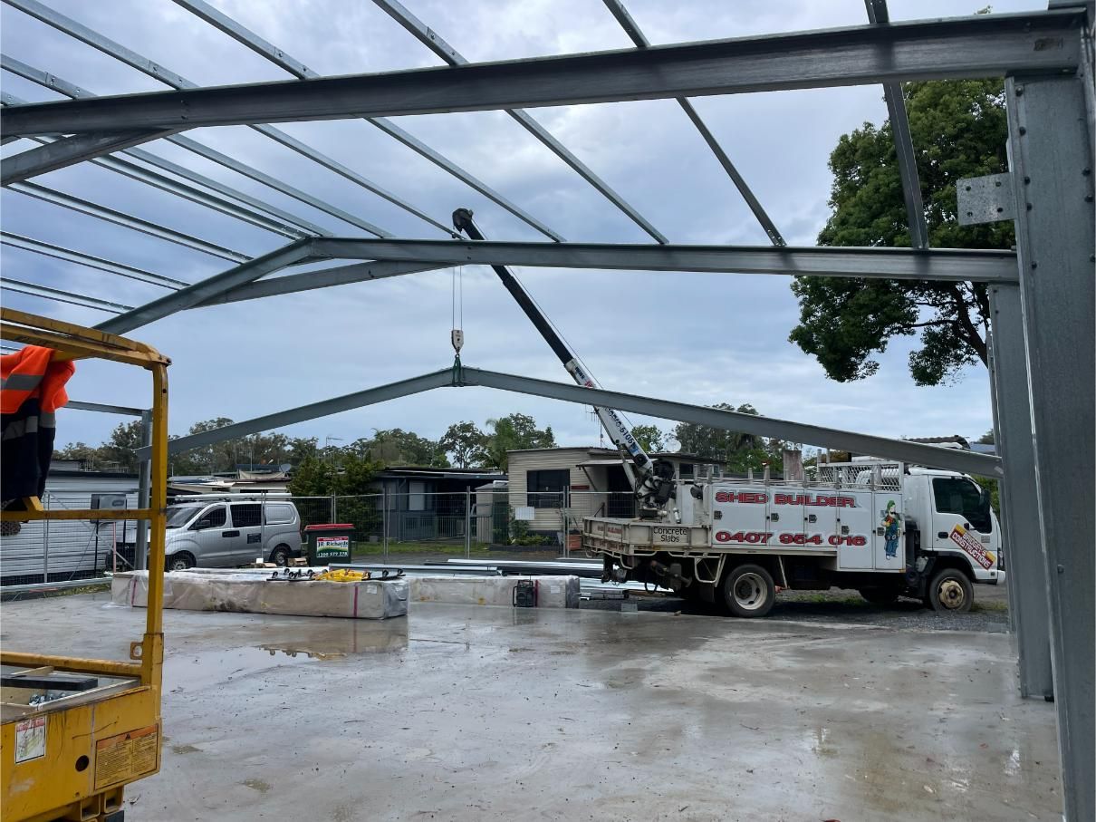 Building Frame On A Wet Site with Work Trucks and Equipment — Bridgey's Constructions in Wallabi Point, NSW