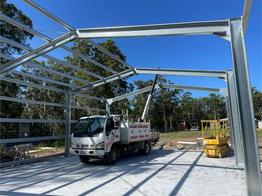 Steel Warehouse Frame Under Construction with A White Truck — Bridgey's Constructions in Wallabi Point, NSW