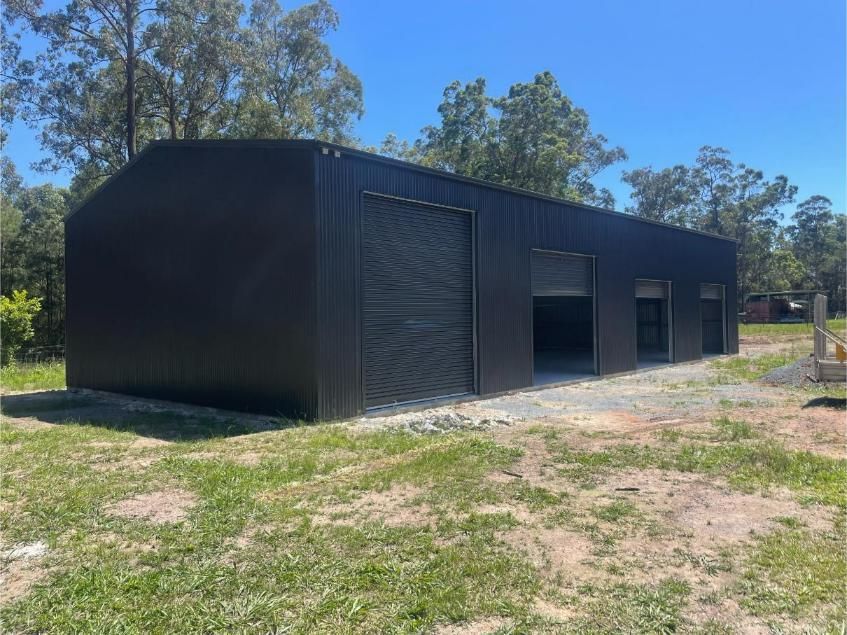 Black Metal Shed With Three Garage Doors — Bridgey's Constructions in Wingham, NSW
