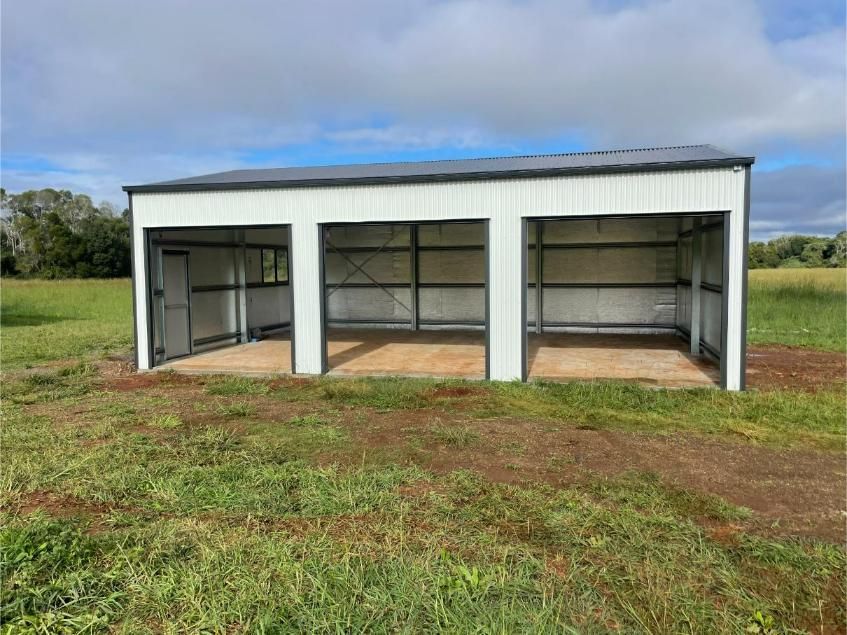 Open Front White Metal Shed with Three Bays on A Grassy Field — Bridgey's Constructions in Diamond Beach, NSW