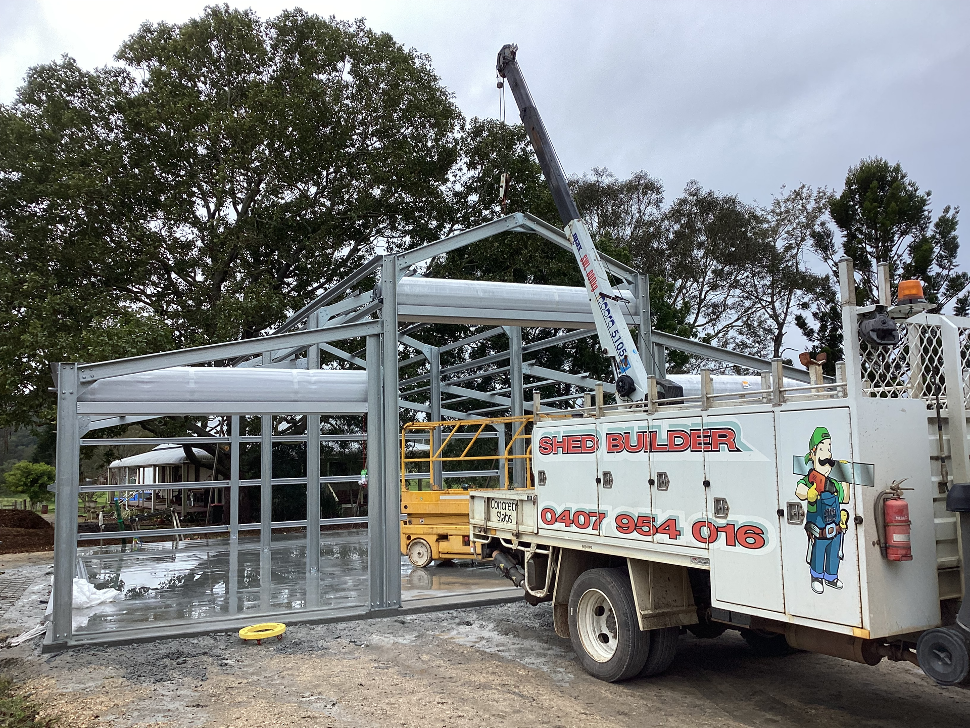 Workers Erecting a Steel Framed Structure Beside a White Utility Truck — Bridgey's Constructions in Diamond Beach, NSW