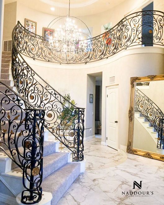 There is a large mirror in the middle of the room next to the stairs.