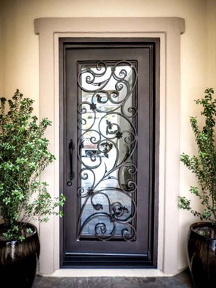 A wrought iron door with a glass window is on a wall.