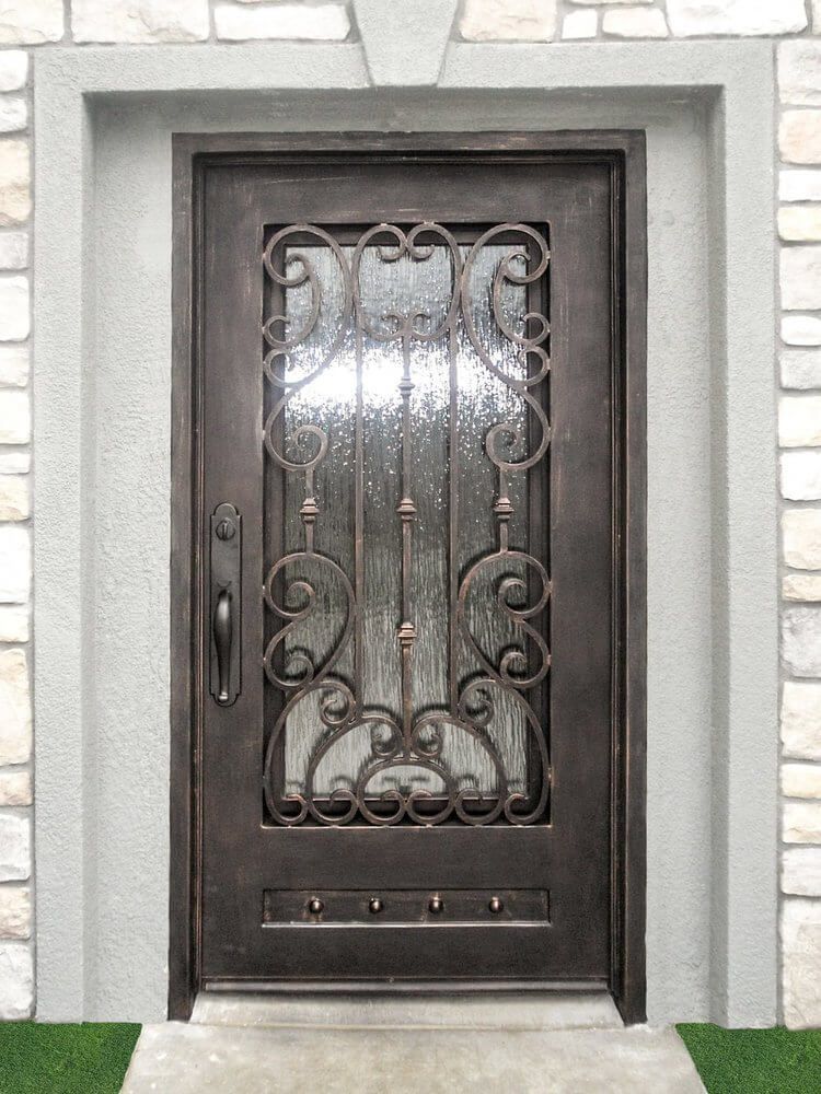 A wrought iron door is sitting on a stone wall.