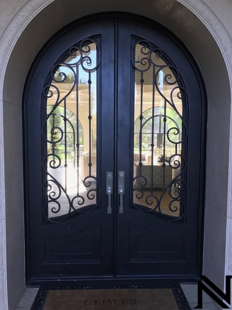 A wrought iron door with a welcome mat in front of it