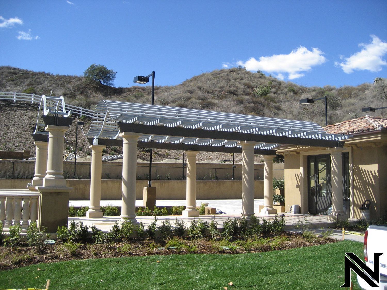 A house with a pergola and a sign that says n on it