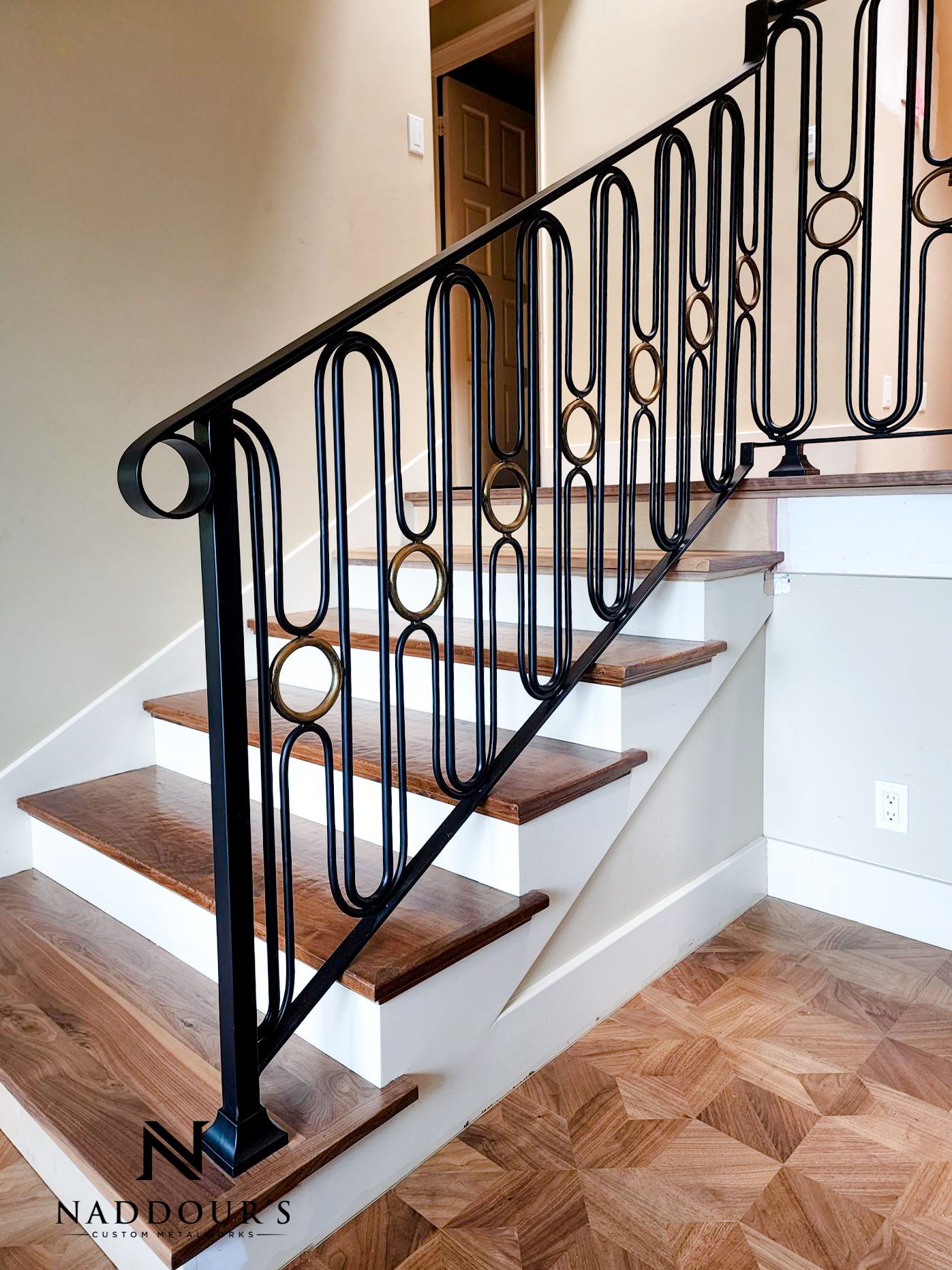 A staircase with a wrought iron railing and wooden steps