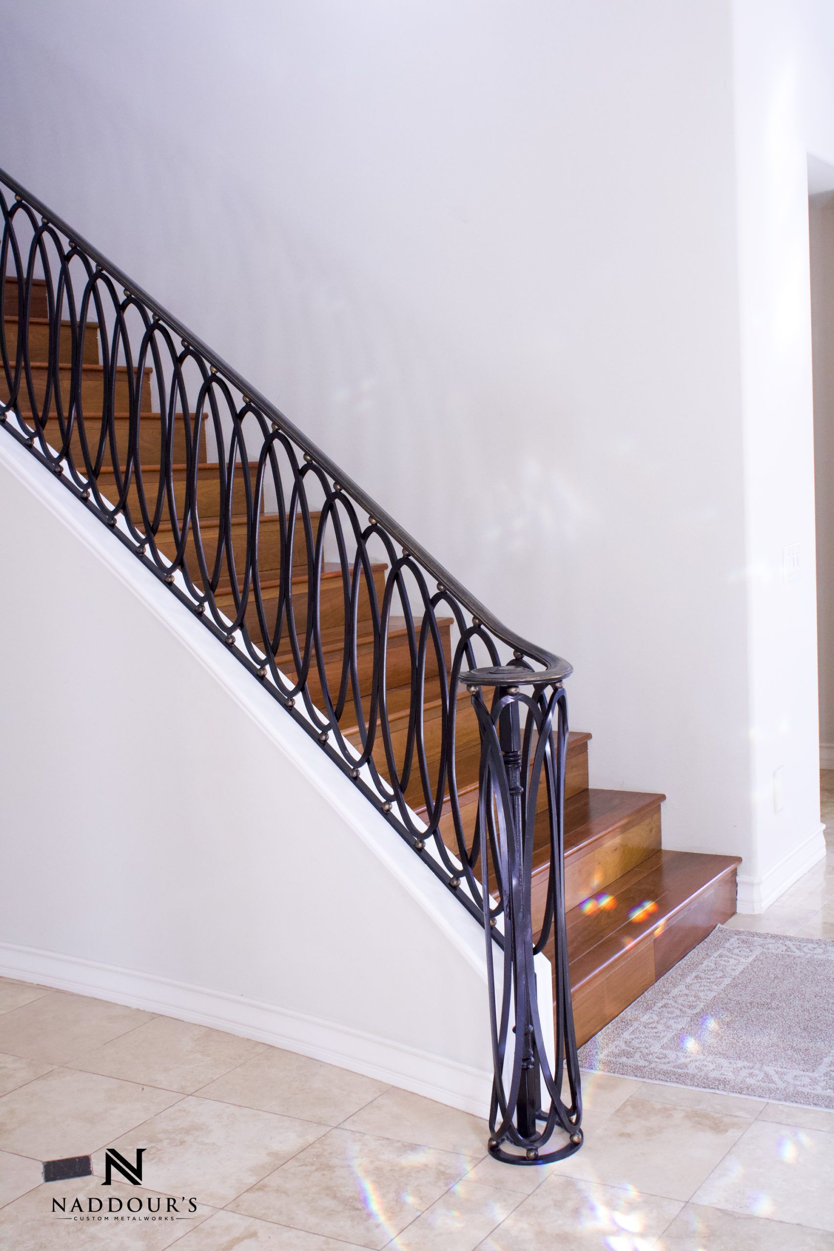 A staircase with a wrought iron railing and wooden steps