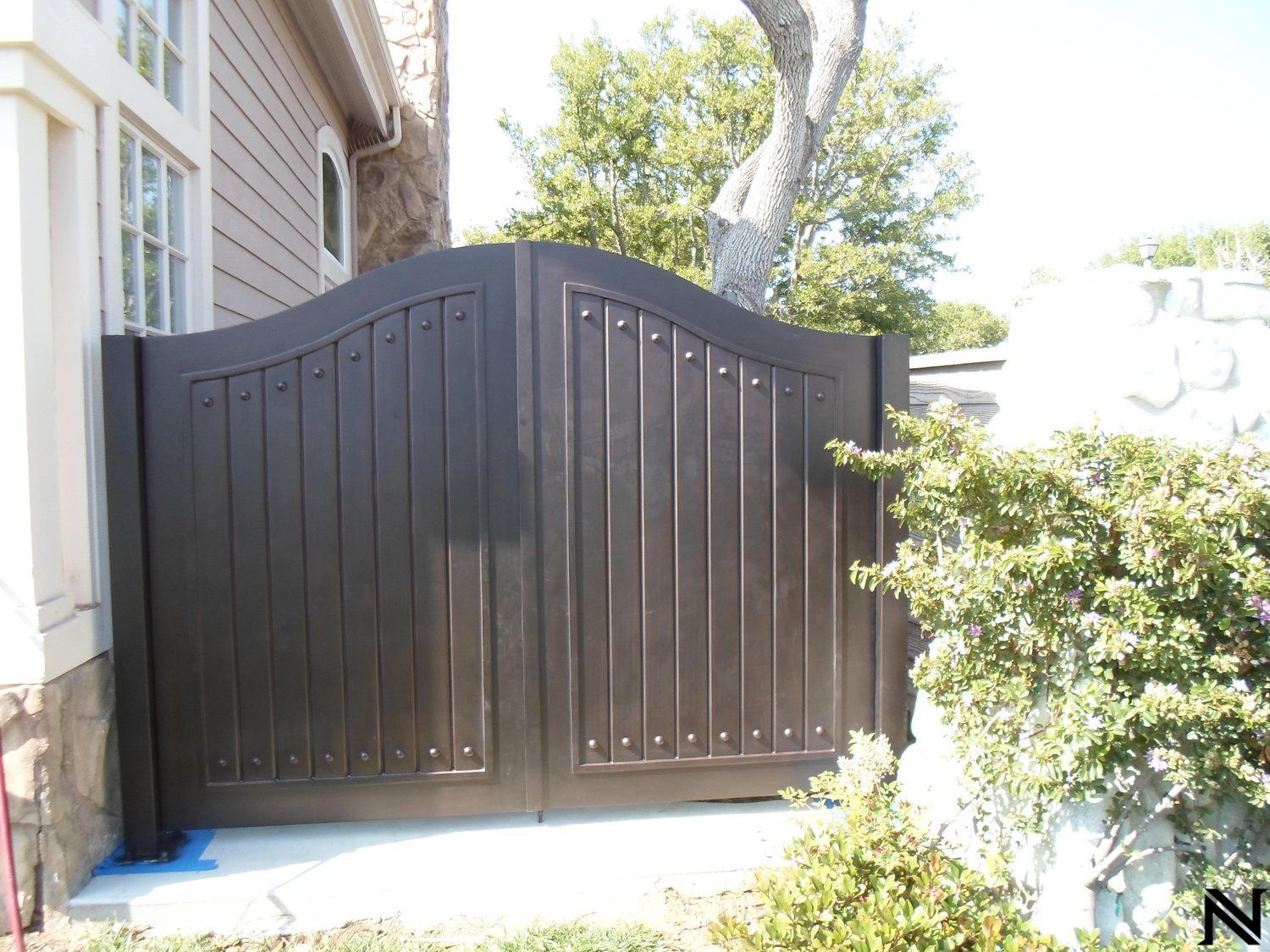 A wooden gate is sitting in front of a house