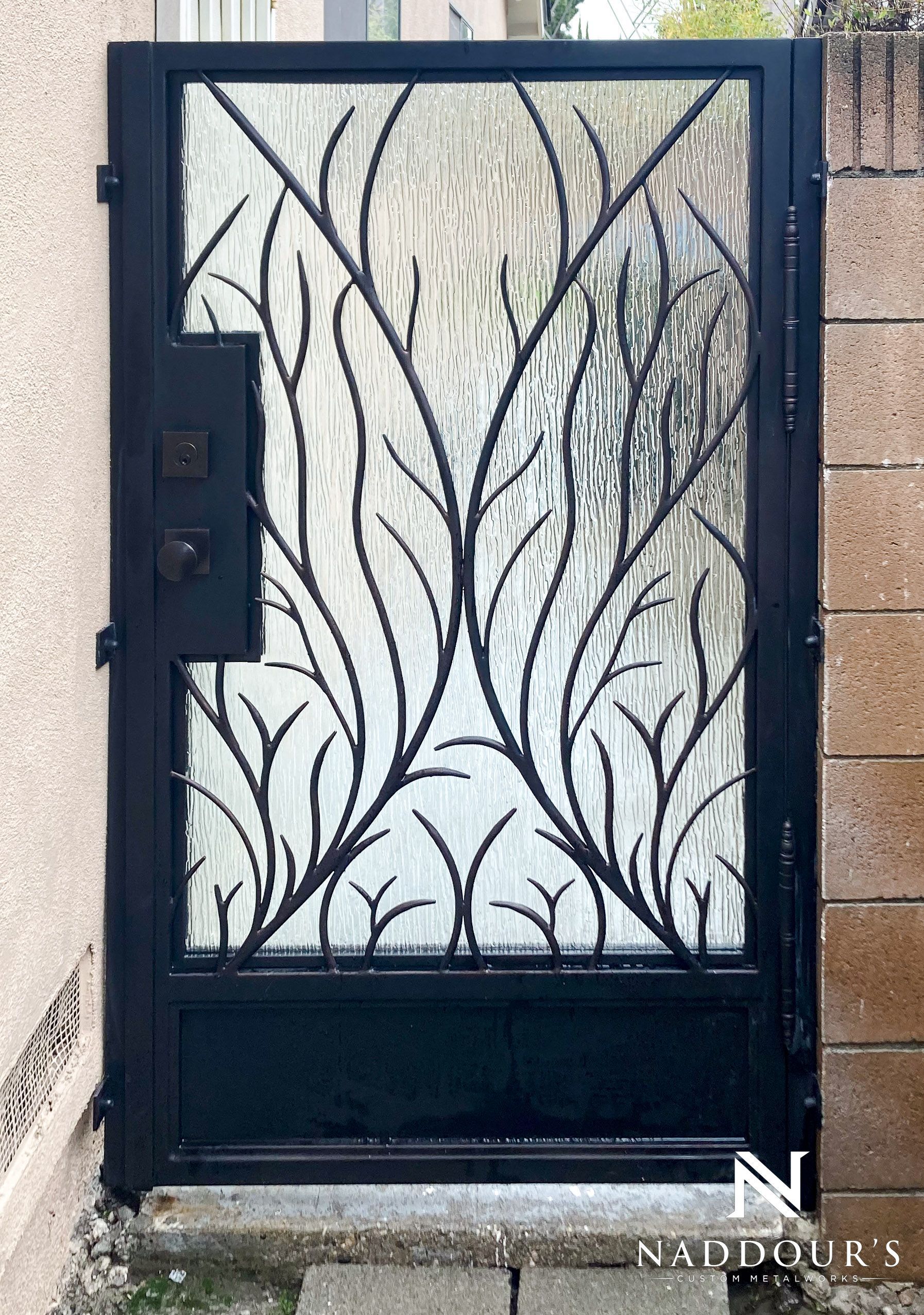 A wrought iron gate with a tree design on it
