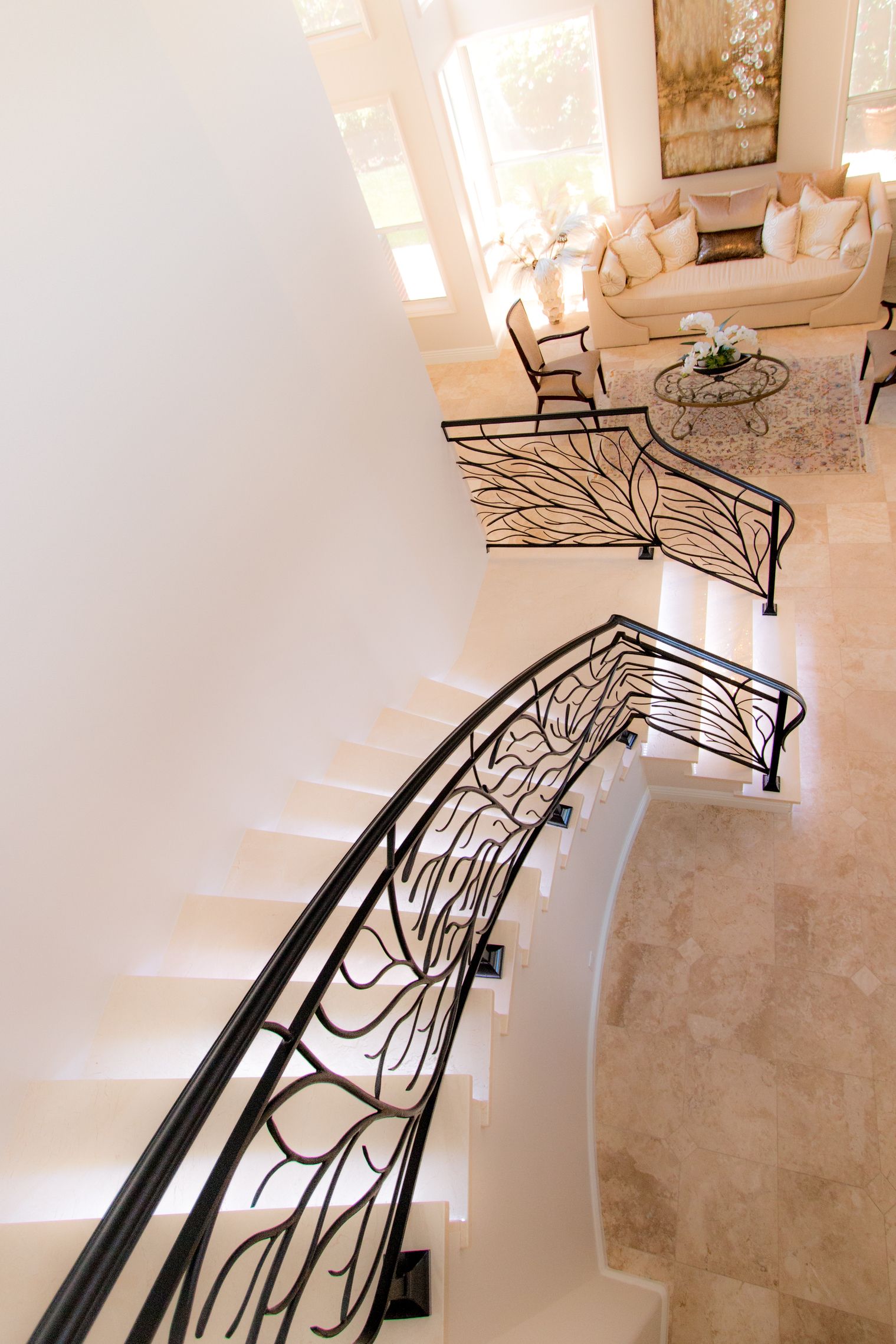 A staircase with a wrought iron railing leading up to a living room