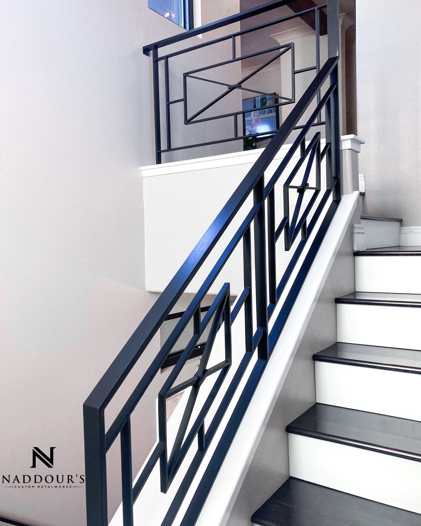 A staircase with a black railing and white steps