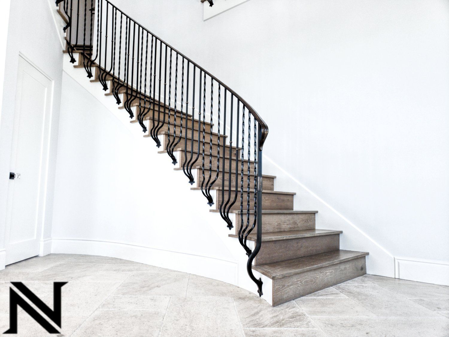 A staircase with a wrought iron railing and the letter n in the corner