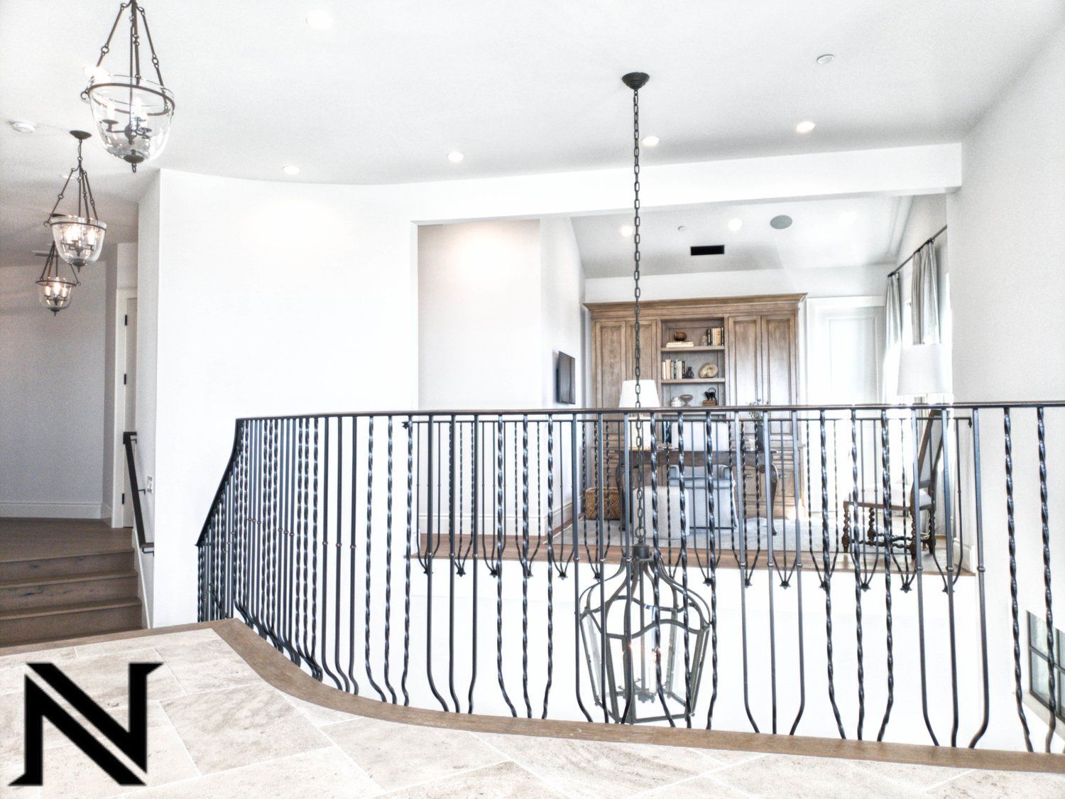 A staircase with a wrought iron railing and the letter n in the corner
