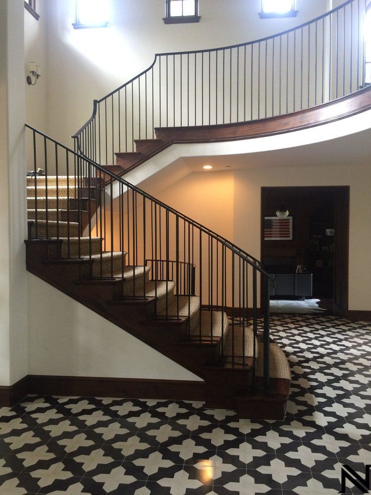 A staircase with a black railing and a patterned floor