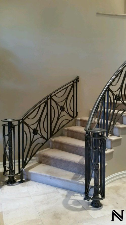 A picture of a staircase with a wrought iron railing