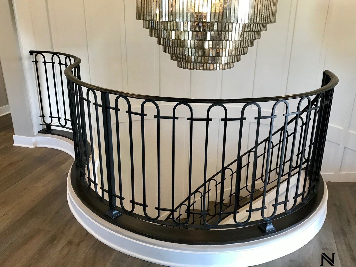 There is a chandelier hanging from the ceiling above the stairs.
