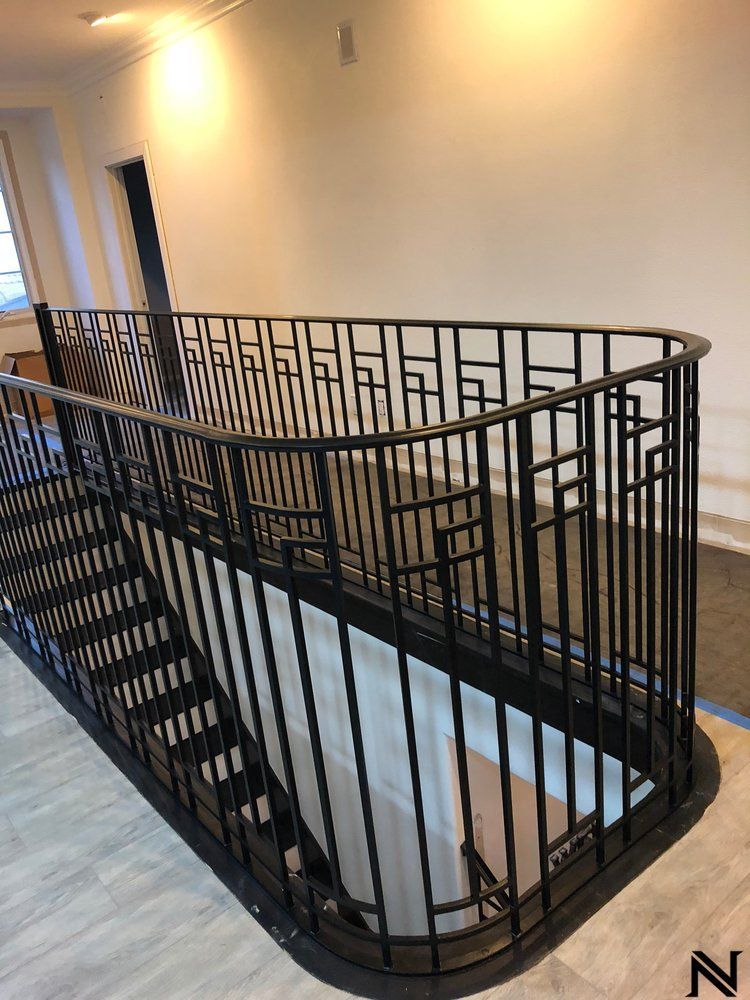 A wrought iron staircase with a railing in a building.