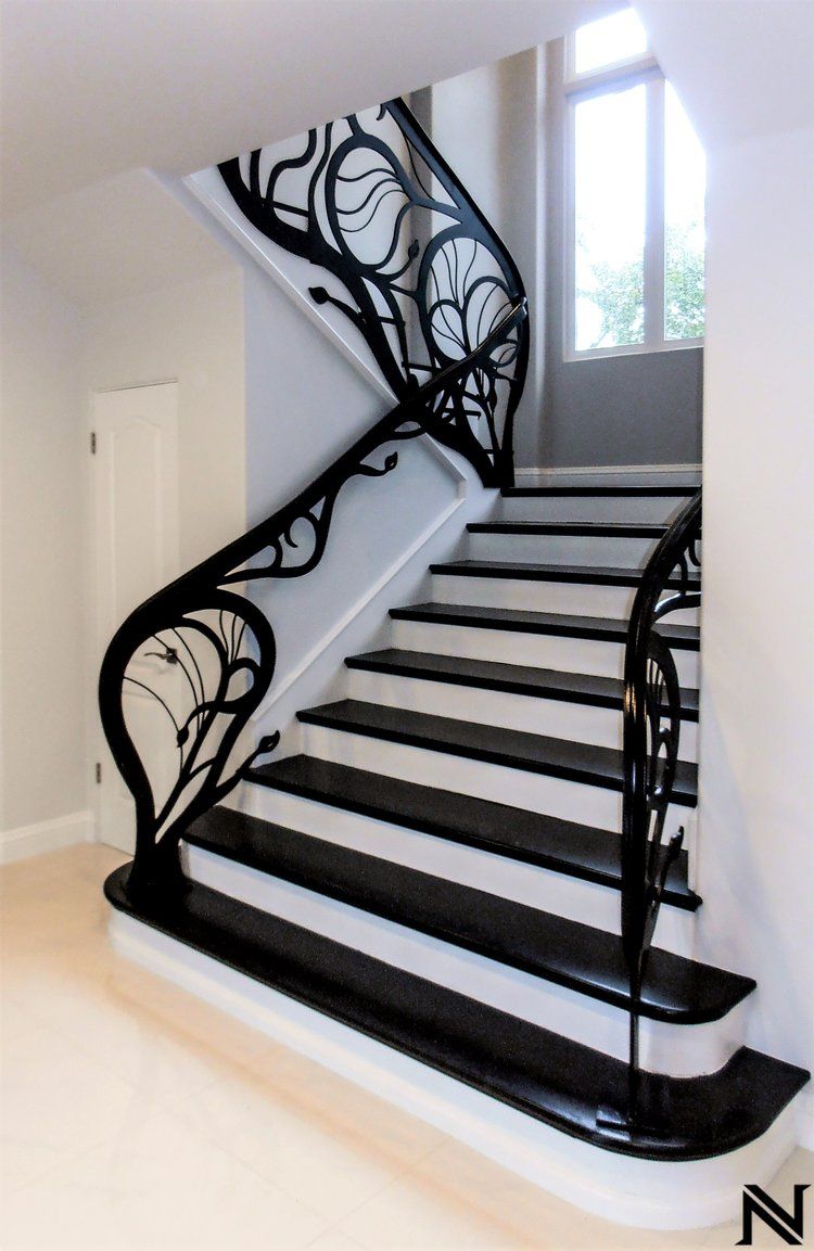 A black and white staircase with a wrought iron railing