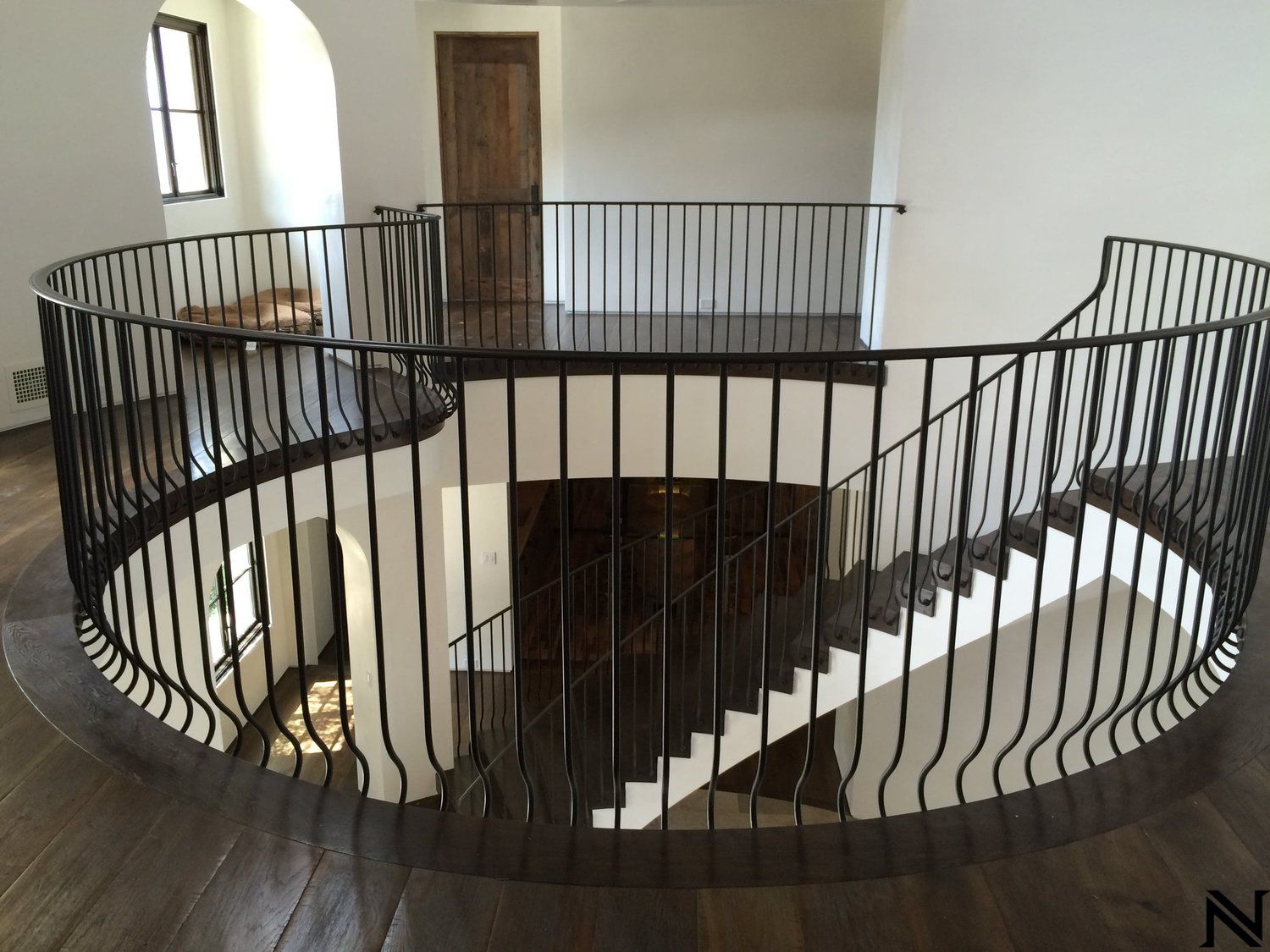 A spiral staircase with a wrought iron railing in a house