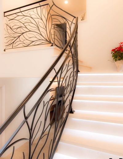 A staircase with a wrought iron railing and white steps