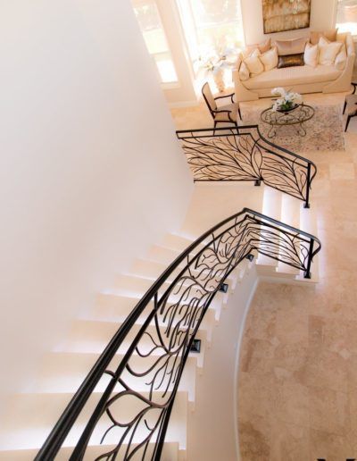 A staircase with a wrought iron railing leading to a living room