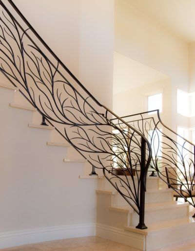 A staircase with a wrought iron railing that looks like a tree